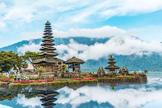 Balinese temple on the water with clouds in background