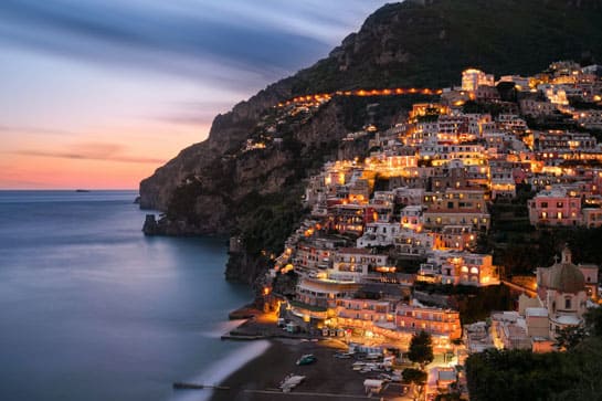 Amalfi coast city lit up at sunset